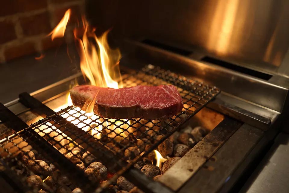 Bife sendo preparado na grelha