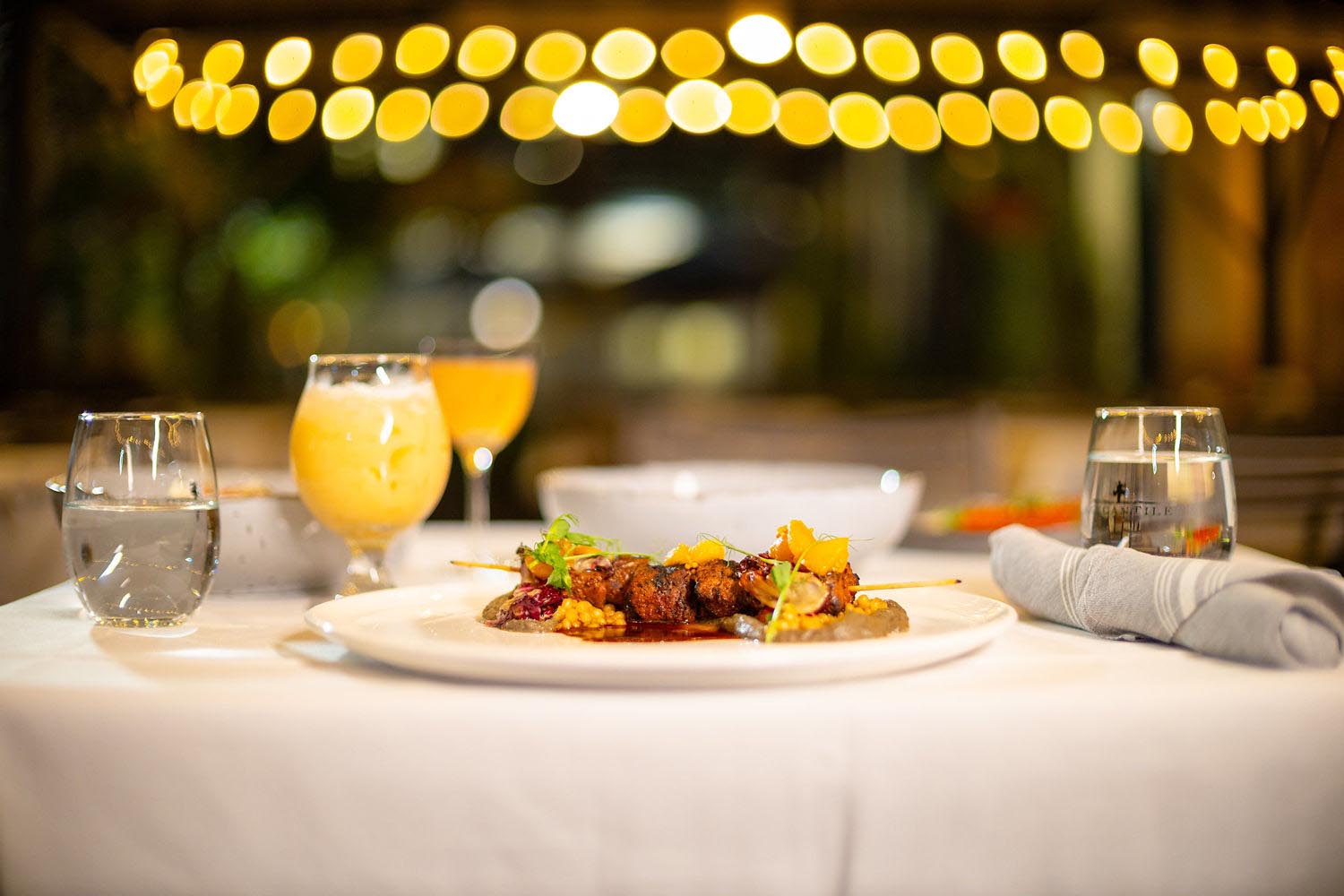 Comida servida em um prato rodeado de bebidas.